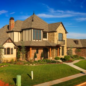 Large suburban home featuring brown shingle roofing